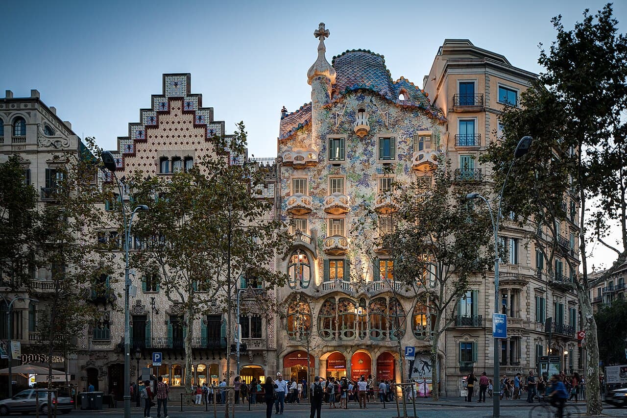 Façade ondulante et colorée de la Casa Batlló de Gaudí illuminée à la tombée de la nuit sur le Passeig de Gràcia à Barcelone