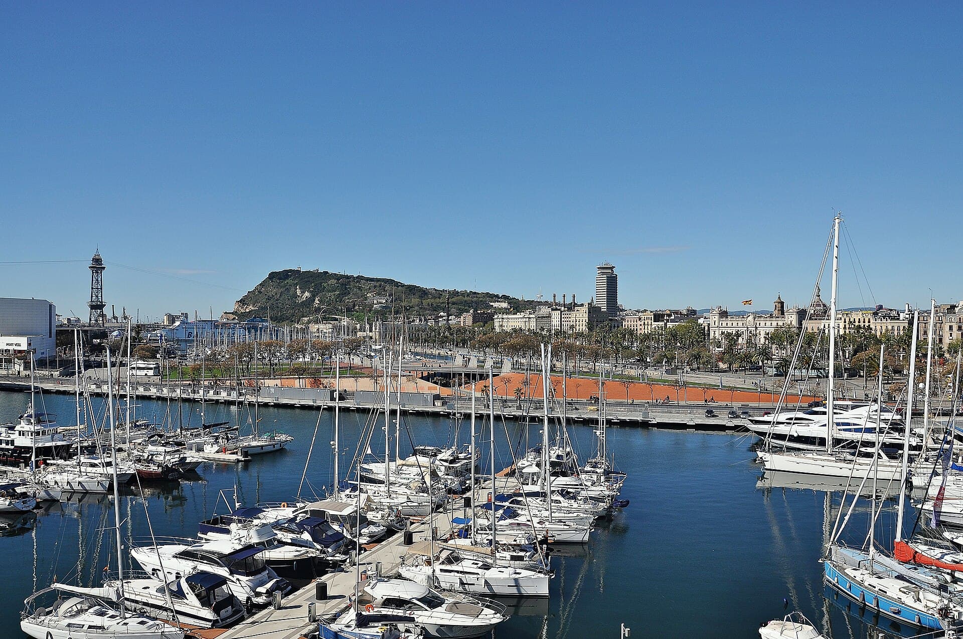 Voiliers amarrés dans le Port Vell de Barcelone avec les quais et la ville en arrière-plan