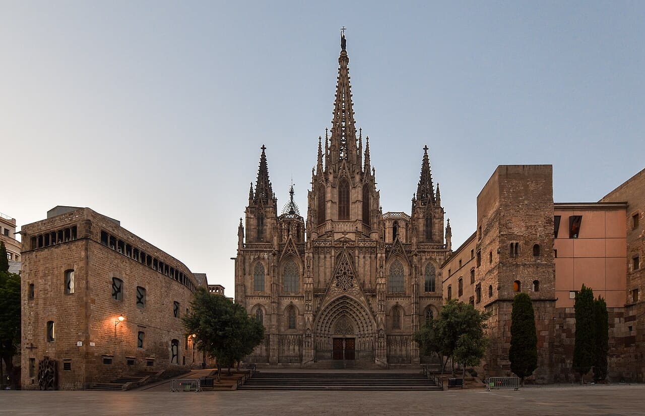 La façade néogothique de la cathédrale de la Santa Creu i Santa Eulàlia de Barcelone vue depuis le Pla de la Seu, avec ses deux tours-clochers et sa flèche centrale