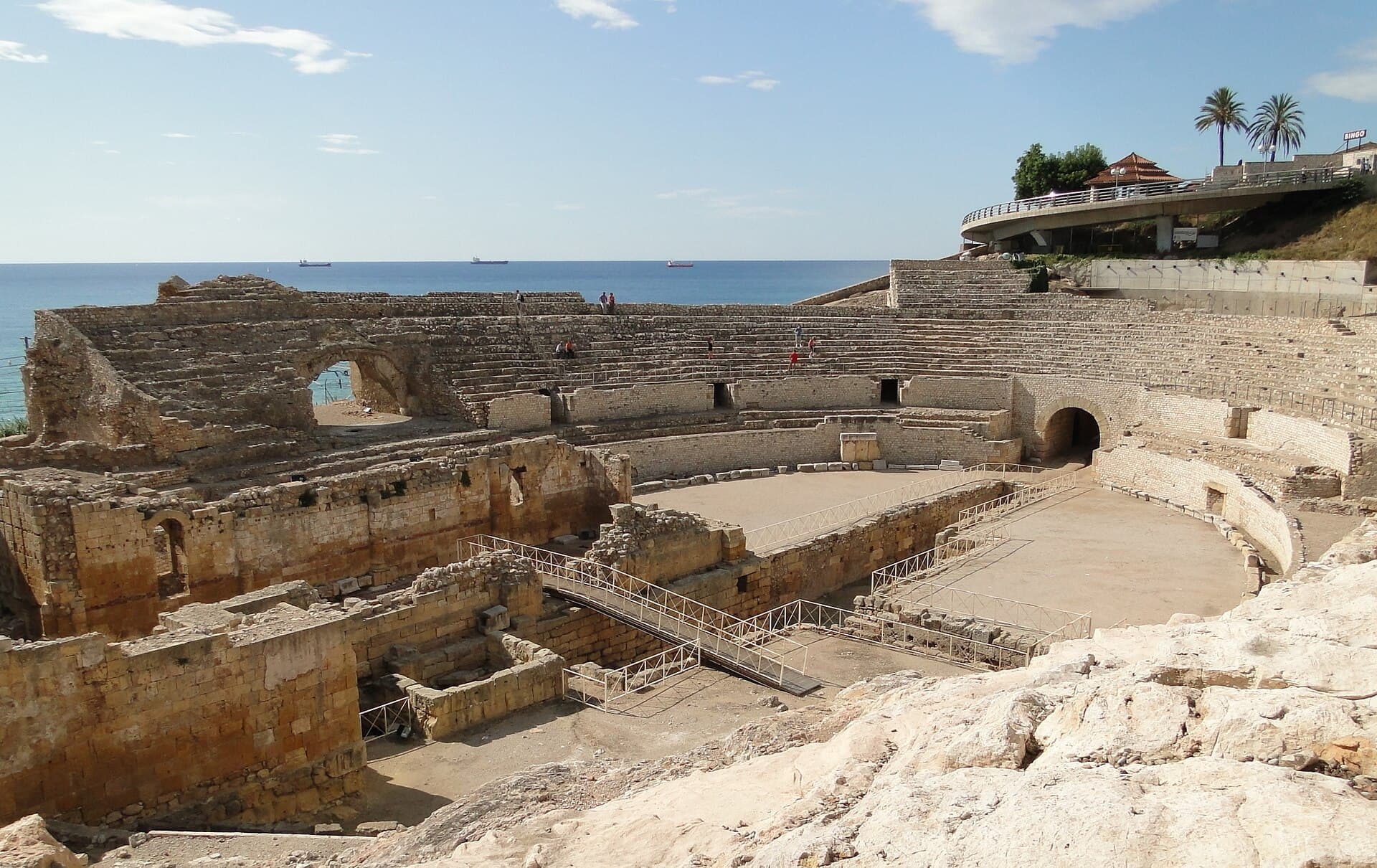 Gradins de l'amphithéâtre romain de Tarragone face à la mer Méditerranée sous un ciel bleu