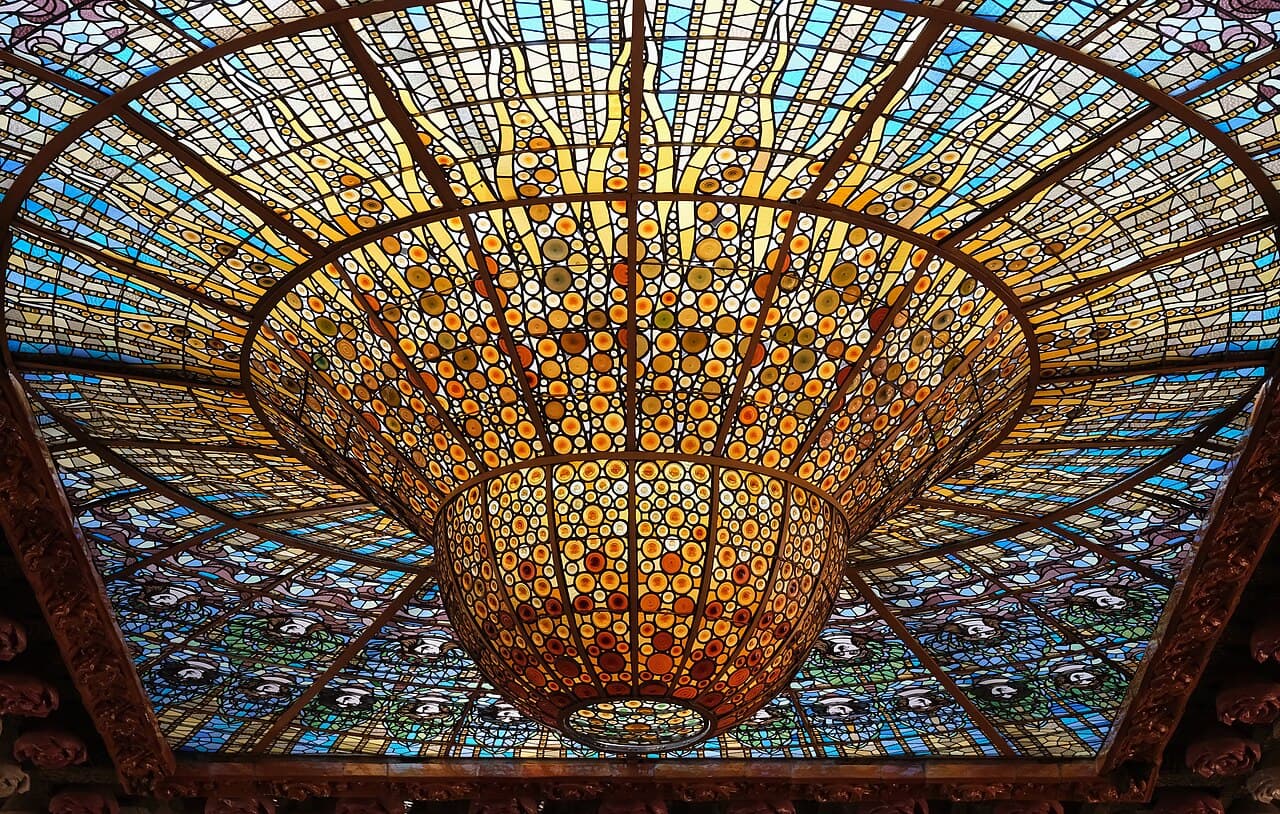 La verrière inversée en vitraux dorés et roses du Palau de la Música Catalana de Barcelone vue depuis la salle de concert