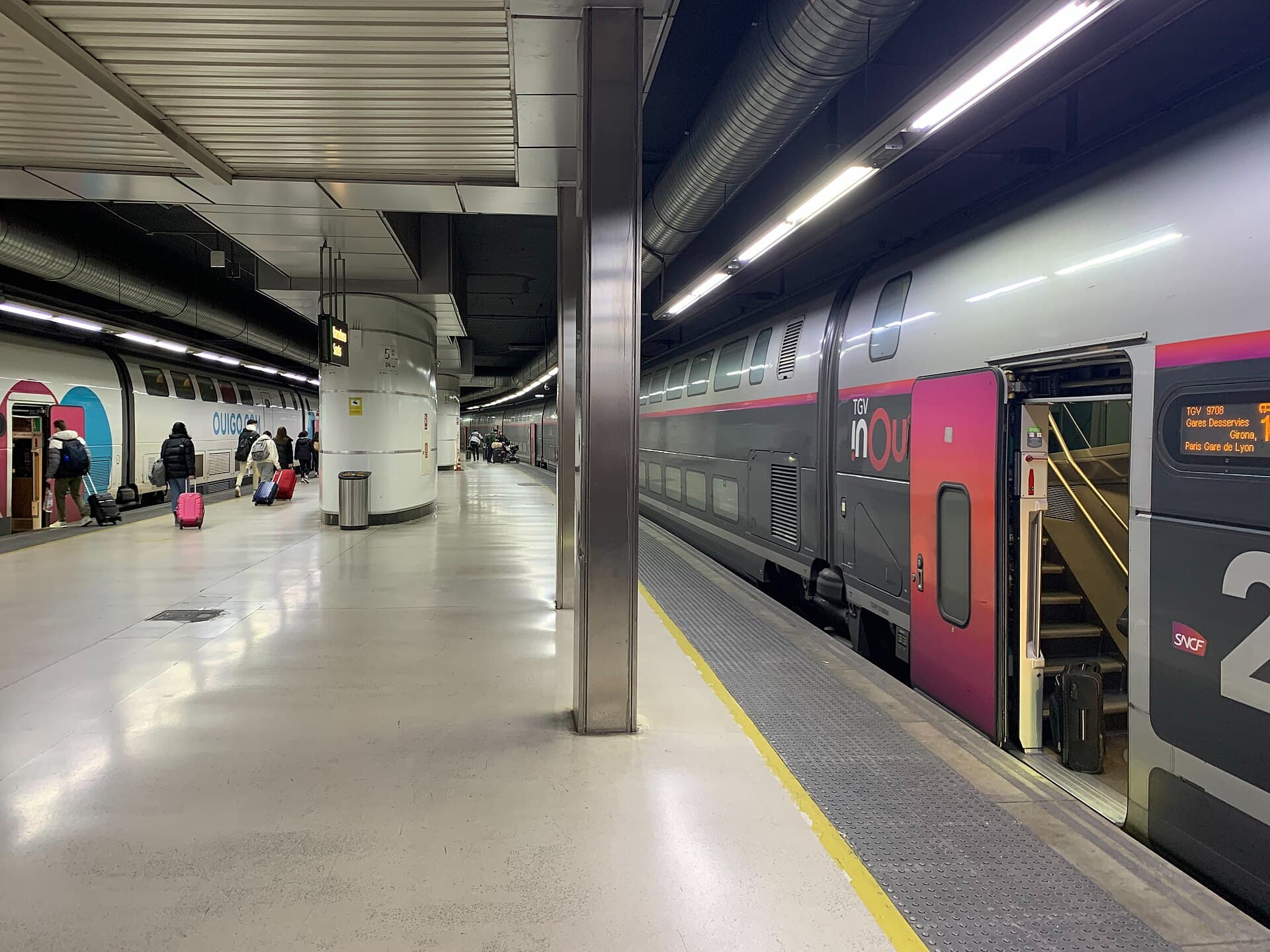 Rames Ouigo et TGV inOui à quai sous la halle de la gare de Barcelona Sants